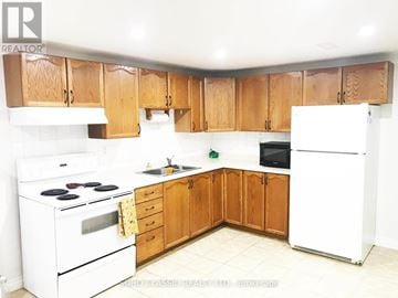 Newmarket (Huron Heights-Leslie Valley) apartment for rent - A kitchen with wooden cabinets and white appliances.