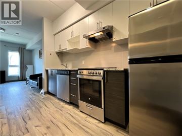 Hamilton condo for rent - A modern kitchen with stainless steel appliances and wooden flooring.