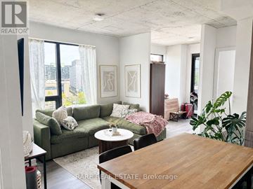 Toronto (Moss Park) condo for rent - A living room with a couch, a chair, a table and a potted plant.