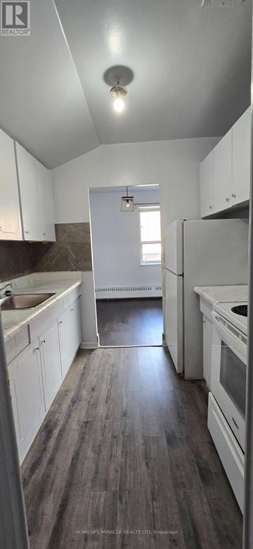 Toronto (Wexford-Maryvale) multi-family for rent - A kitchen with white cabinets and a wooden floor.