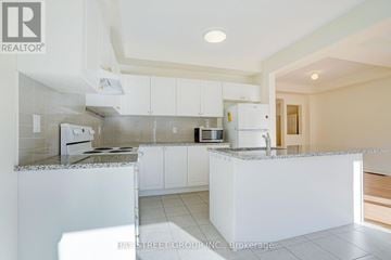 Richmond Hill townhouse for rent - A kitchen with white cabinets and a granite countertop.