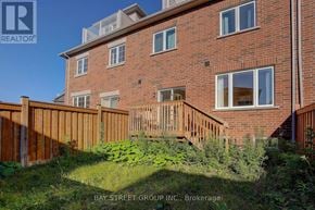 Richmond Hill townhouse for rent - A red brick building with a wooden fence in front.