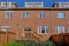 Richmond Hill townhouse for rent - A red brick building with a balcony and a fence.