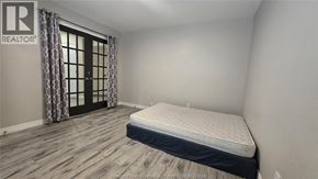 Windsor apartment for rent - A bedroom with a bed, wooden flooring, and a window with curtains.