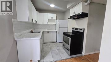 Windsor apartment for rent - A kitchen with white cabinets and a black stove top oven.