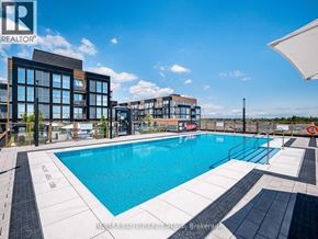 Oakville (Wm Westmount) condo for rent - A swimming pool area with a building in the background.