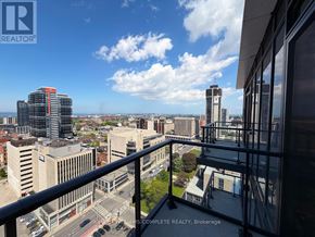 Hamilton (Corktown) condo for rent - A cityscape viewed from a balcony with a sign that reads "REALTOR".