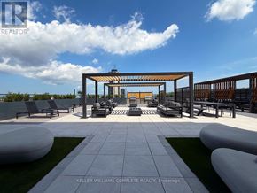 Hamilton (Corktown) condo for rent - A modern outdoor seating area with a white and grey tiled floor and a wooden pergola.