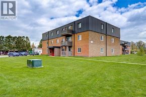 London apartment for rent - A large building with a grassy area in front and a blue sky above.