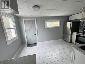 Sault Ste. Marie apartment for rent - A kitchen with white tile flooring and a white door.