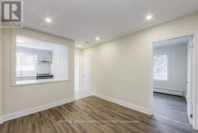 Toronto (Bathurst Manor) triplex for rent - A spacious room with wood flooring and white walls.