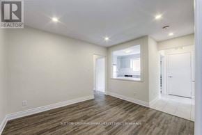 Toronto (Bathurst Manor) triplex for rent - A spacious room with wood flooring and white walls.