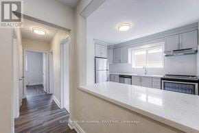 Toronto (Bathurst Manor) triplex for rent - A kitchen with white countertops and a stainless steel refrigerator.