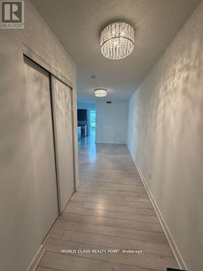 Toronto (Bayview Village) condo for rent - A hallway with a chandelier and a sign that says "WORLD CLASS REALITY POINT Brokerage".
