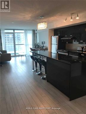 Toronto (Bayview Village) condo for rent - A modern kitchen with a black countertop and stainless steel appliances.