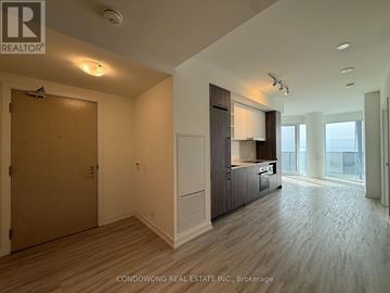 Toronto (Waterfront Communities) condo for rent - A spacious room with wood flooring and a large window.
