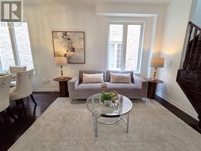 Markham (Wismer) apartment for rent - A living room with a grey couch, a glass coffee table, and a painting on the wall.