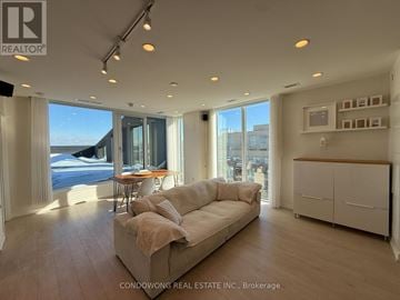 Toronto (Weston-Pellam Park) condo for rent - A spacious living room with a large couch and a dining table.