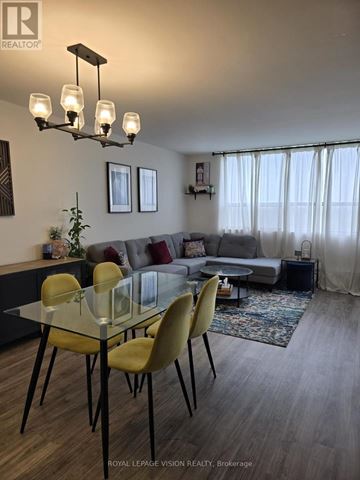 Toronto (Victoria Village) condo for rent - A well-lit living room with a glass table and yellow chairs.