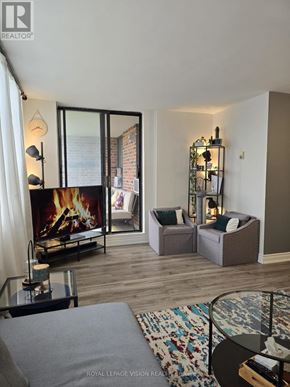 Toronto (Victoria Village) condo for rent - A living room with a fireplace and a glass table.