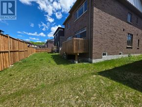 Springwater (Midhurst) apartment for rent - A house with a brown fence and a green lawn.