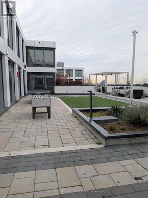 Toronto (York University Heights) condo for rent - A modern building with a patio and a bench.