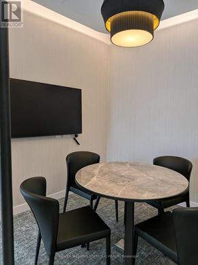 Toronto (York University Heights) condo for rent - A conference room with a table, chairs, and a television.