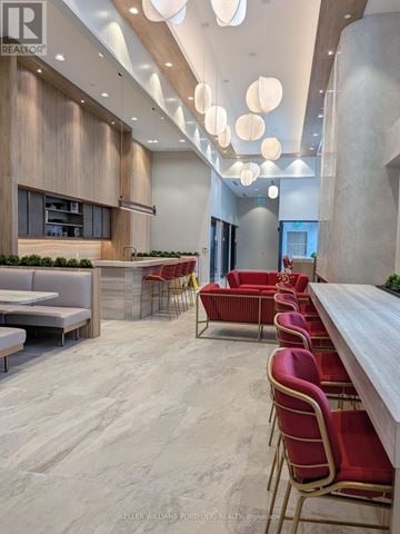 Toronto (York University Heights) condo for rent - A modern dining area with red chairs and a long table.