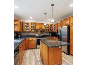 Surrey apartment for rent - A kitchen with wooden cabinets and a black countertop.