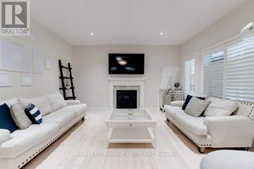 Hamilton (Stoney Creek) apartment for rent - A living room with white furniture and a fireplace.
