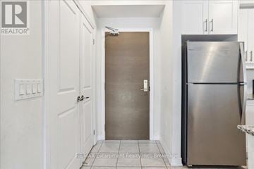 Oakville (Wm Westmount) townhouse for rent - A kitchen with a refrigerator and a door in the middle.