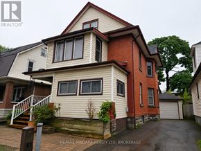 Welland (Welland Downtown) triplex for rent - A two-story house with a red brick exterior and a white front porch.
