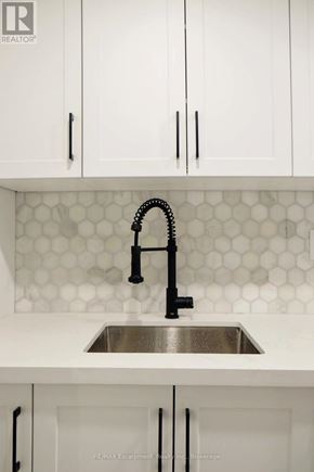 Toronto (Regent Park) townhouse for rent - A modern kitchen with a sink and cabinets.