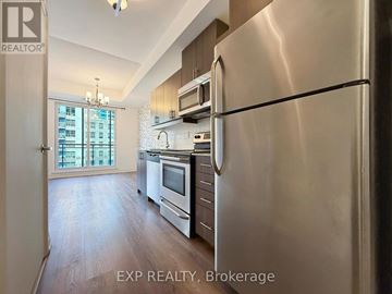 Toronto (Bayview Village) condo for rent - A stainless steel refrigerator in a well-lit kitchen with wooden floors and modern appliances.