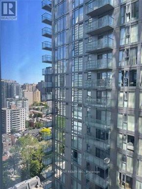 Toronto (Church-Yonge Corridor) condo for rent - A tall building with many windows and balconies is seen from a high vantage point.