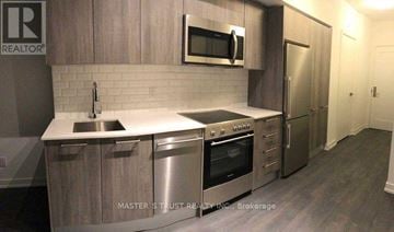 Toronto (Church-Yonge Corridor) condo for rent - A kitchen with a stainless steel refrigerator and a microwave above the stove.