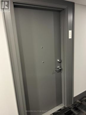 Guelph (Grange Road) condo for rent - A grey door with a handle and a key slot.