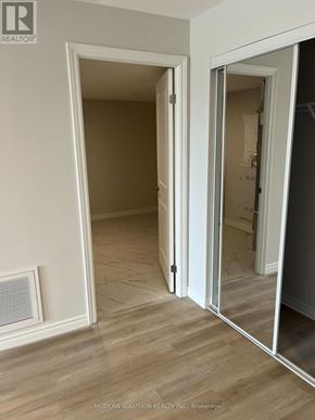 Guelph (Grange Road) condo for rent - A room with a wooden floor and a white door.