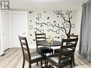 Niagara Falls (Cherrywood) multi-family for rent - A dining room with a tree mural on the wall and a table with chairs.