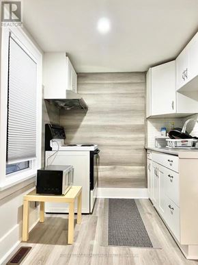 Niagara Falls (Cherrywood) multi-family for rent - A small kitchen with a microwave, oven, and sink.