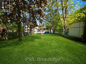 Kitchener apartment for rent - A backyard with a fence and trees.