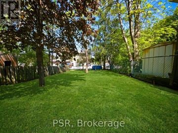 Kitchener apartment for rent - A backyard with a fence and trees.