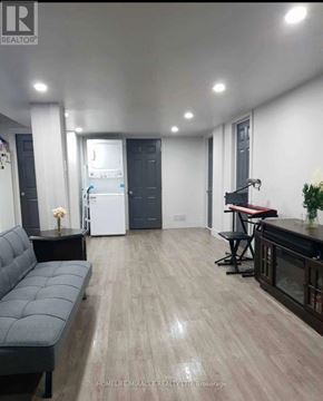 Vaughan (Elder Mills) apartment for rent - A modern living room with a grey sofa and a kitchen area in the background.