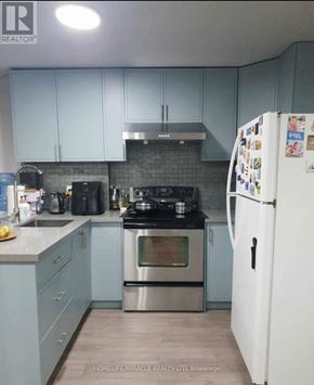 Vaughan (Elder Mills) apartment for rent - A kitchen with a white fridge and a stove top oven.