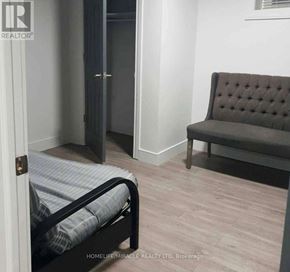 Vaughan (Elder Mills) apartment for rent - A bedroom with a bed, a bench, and a door.