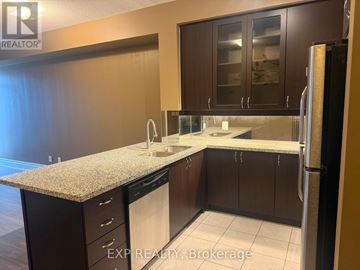 Markham (Unionville) condo for rent - A kitchen with dark brown cabinets and a granite countertop.