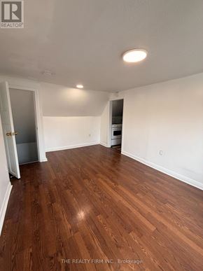 London East (East M) duplex for rent - A room with wooden flooring and white walls, with a door on the left side.