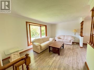 St. Catharines (Glendale/Glenridge) apartment for rent - A living room with a white couch and a glass table.