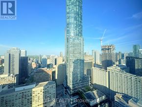 Toronto (Bay Street Corridor) condo for rent - A cityscape with a tall skyscraper in the center and a crane in the background.