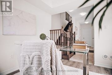 Oakville (Go Glenorchy) townhouse for rent - A cozy living room with a couch covered in a white knitted throw.